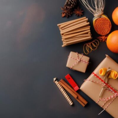 flat-lay-rustic-holiday-gift-wrapping-supplies-including-brown-paper-twine-dried-oranges-candles-fresh-oranges-dark-surface_-gifts for corporate events