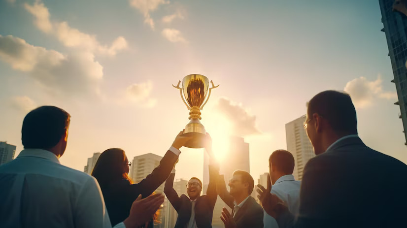 business-people-holding-gold-trophy-award-celebrate-together_- corporate gifting events
