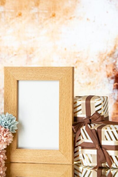 front-view-blank-picture-frame-holiday-presents-flowers-isolated-beige-abstract-background_-