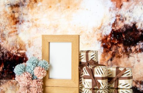 front-view-blank-picture-frame-holiday-presents-flowers-isolated-beige-abstract-background_-