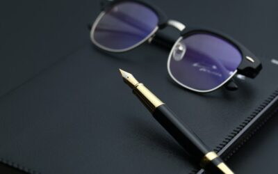 golden-pen-notebook-calculator-glasses-black-desk_-