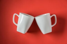 top-view-two-white-ceramic-coffee-cups-red_-