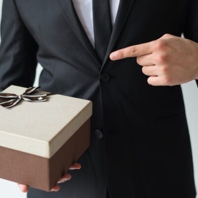 unrecognizable-businessman-holding-brown-gift-box_-