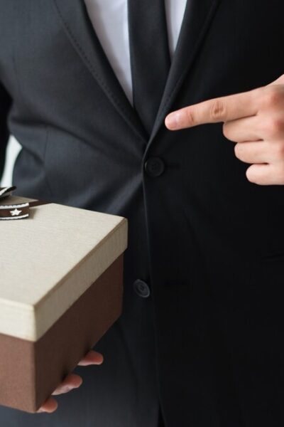 unrecognizable-businessman-holding-brown-gift-box_-