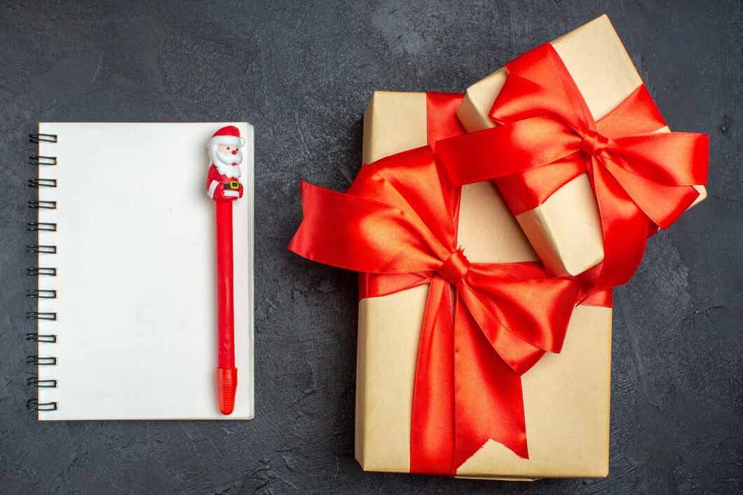 view-christmas-background-with-beautiful-gifts-with-bow-shaped-ribbon-notebook-with-pen-dark-background_-